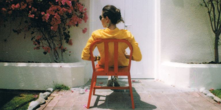 Chaise rouge, femme avec pull jaune