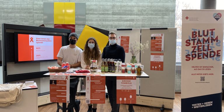 Le comité d'organisation de l'événement St. Gallen gegen Leukämie se tient derrière une table d'information.
