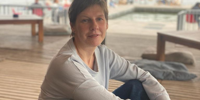 Elin sitzt draussen auf einer Terrasse