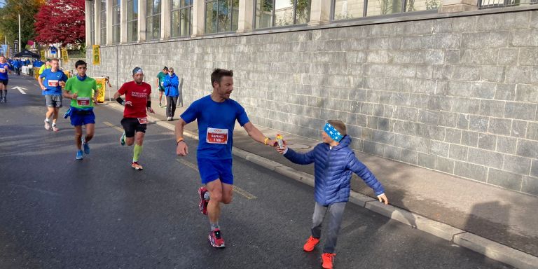 Raphael beim Marathon, sein Sohn gibt ihm eine Wasserflasche