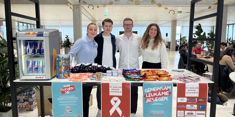 Vier Studierende stehen hinter ihrem Stand mit Give Aways und Informationsmaterial zur Blutstammzellspende