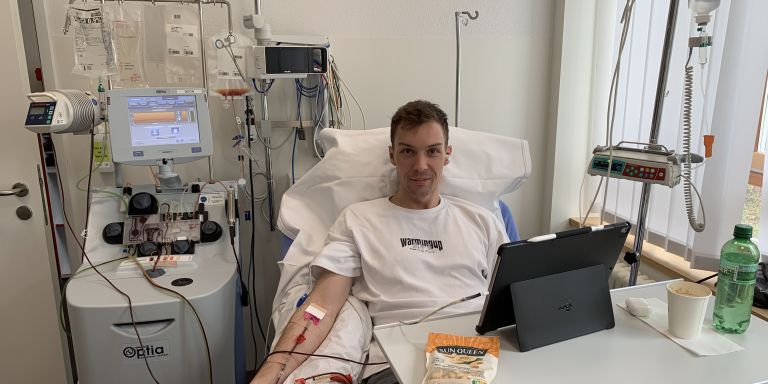 Severin Schmugge während der Blutstammzellspende im Spitalbett, vor sich ein iPad und Nüsse