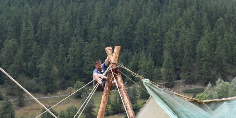 Ivo Binggeli ist als Pfadfinder dabei die Holzmasten eines grossen Zelts zu befestigen.