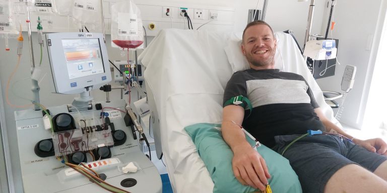 Ramon Klaus liegt im Spitalbett während Spende und lächelt in die Kamera