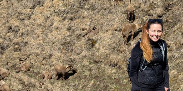 Ladina Gall en randonnée sur un versant montagneux en pente, couvert de mousse et d’herbe.