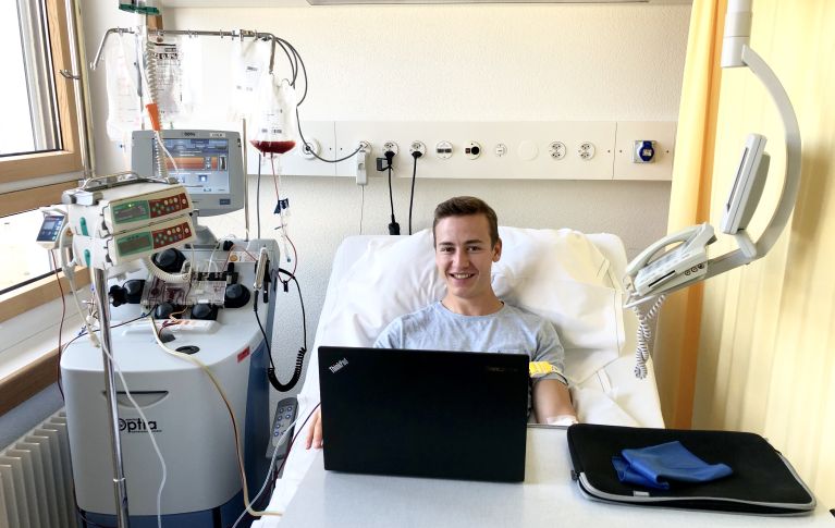 La photo montre un jeune homme pendant le don de cellules souches du sang périphérique.