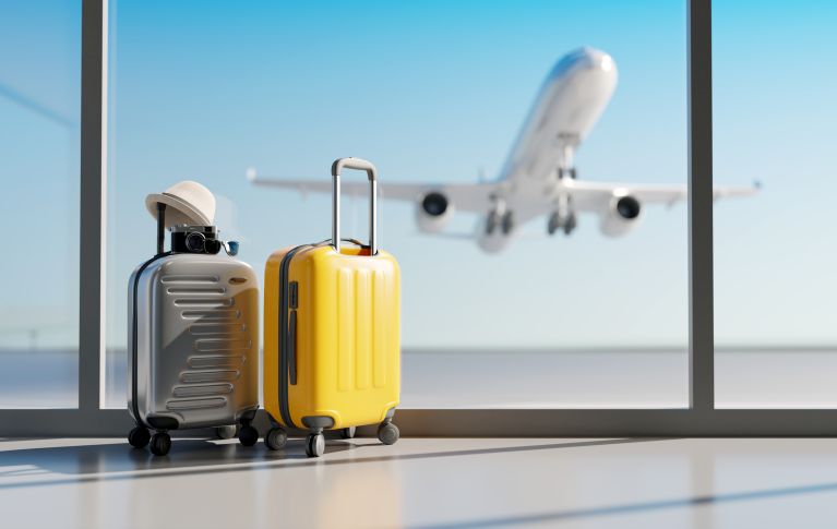 Zwei Koffer am Flughafen mit einem Flugzeug im Hintergrund