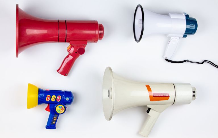Vier Megafone in verschiedenen Ausführungen und Farben