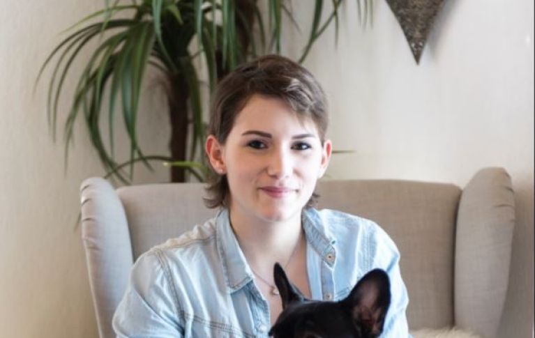 I capelli di Domenique stanno ricrescendo, nella foto la si vede con il cane di famiglia. 