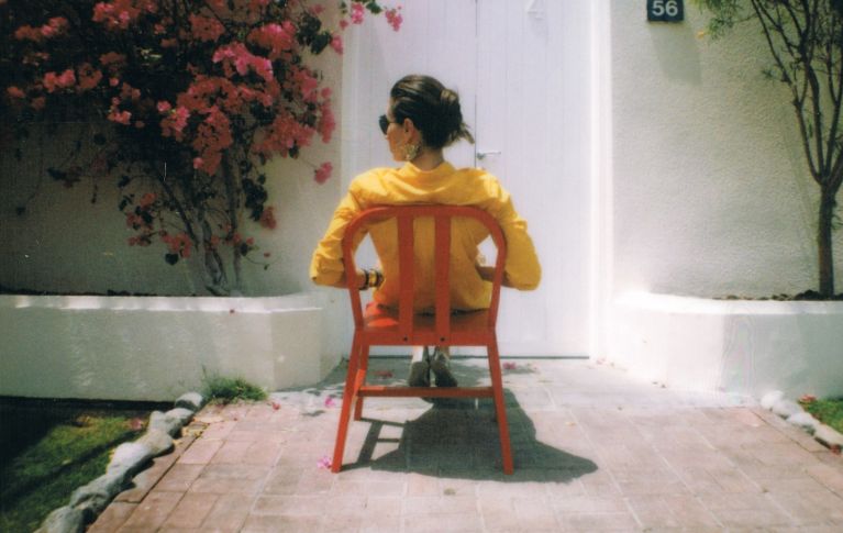 Sedia rossa, donna con maglione giallo
