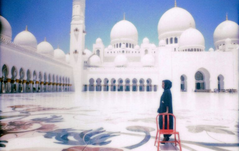 Chaise rouge devant une mosquée