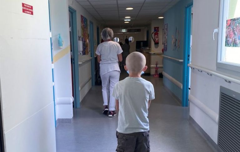 Si vede Daniel di spalle, in piedi nel corridoio di un ospedale.