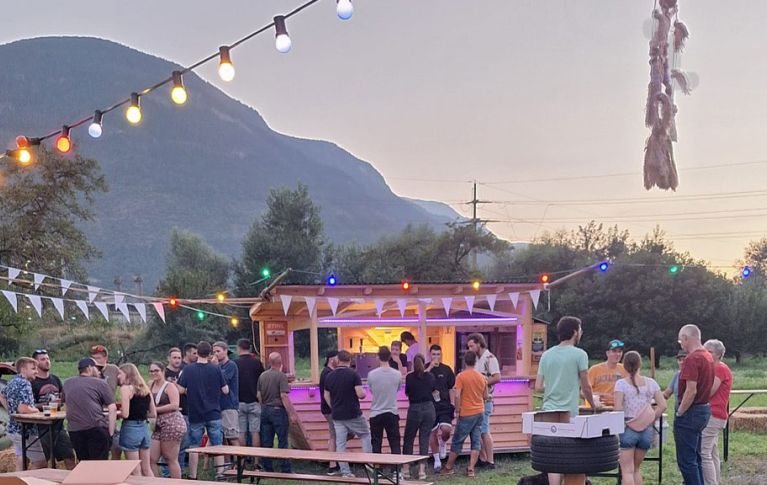 Die Aufnahme zeigt eine Gruppe Menschen bei einer Party unter freiem Himmel.