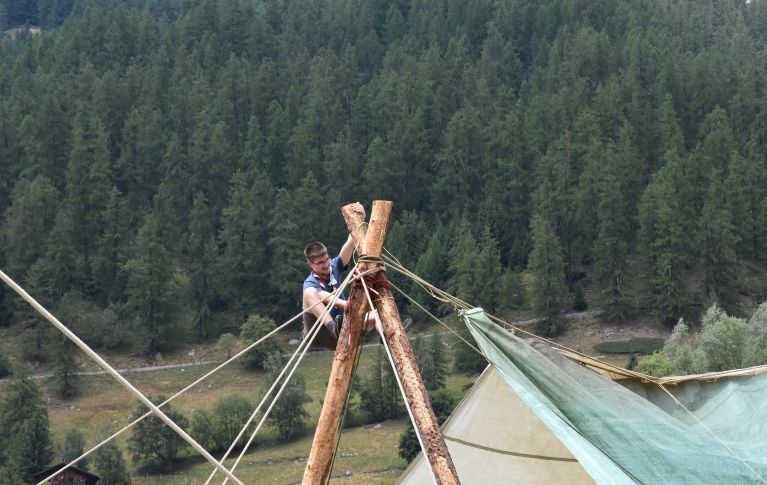 Ivo Binggeli ist als Pfadfinder dabei die Holzmasten eines grossen Zelts zu befestigen.