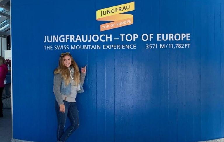 Ladina Gall devant un mur bleu avec l’inscription "Jungfraujoch - Top of Europ"