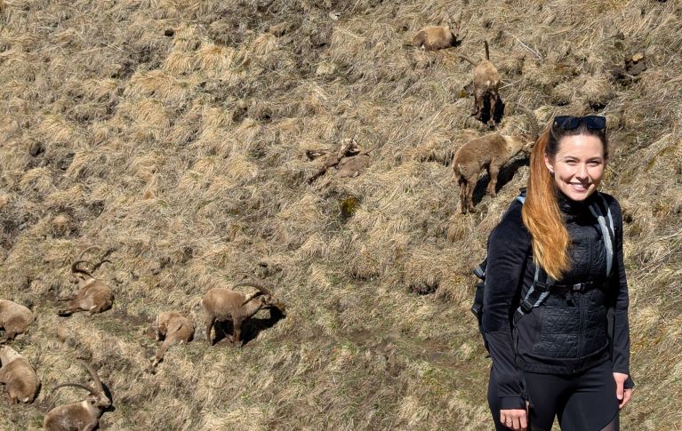 Ladina Gall en randonnée sur un versant montagneux en pente, couvert de mousse et d’herbe.