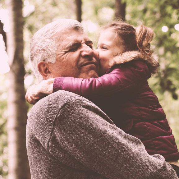 Grossvater trägt Enkelin auf dem Arm