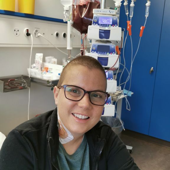 Myriam im Spitalbett am Tag der Transplantation. Der Beutel mit den gespendeten Blutstammzellen im Hintergrund.